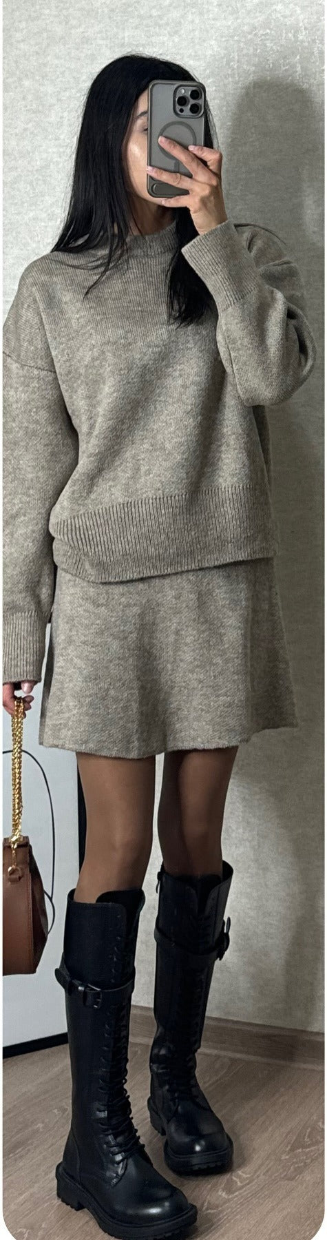 Kobieta w dzianinowym komplecie sweter i spódnica mini